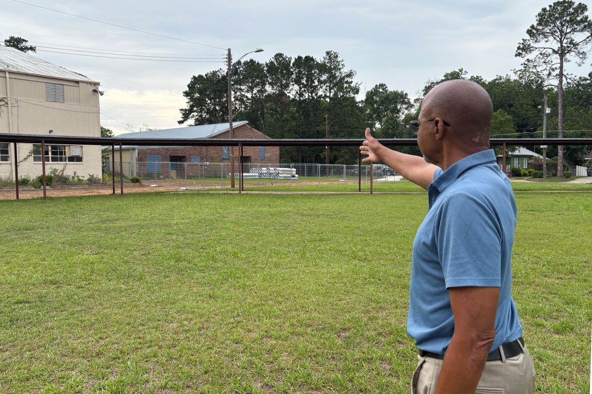 thomasville_05-min A photo of Earl Williams pointing to an old high school building.
