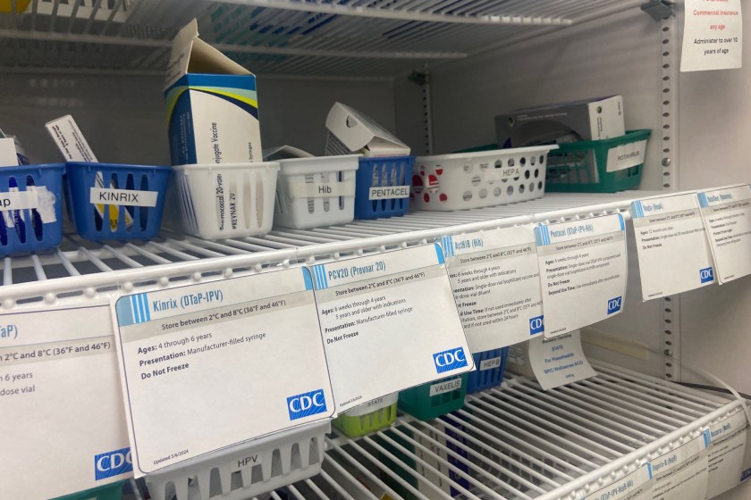 vials Medical products in white baskets rest on a shelf with CDC labels in front of them.