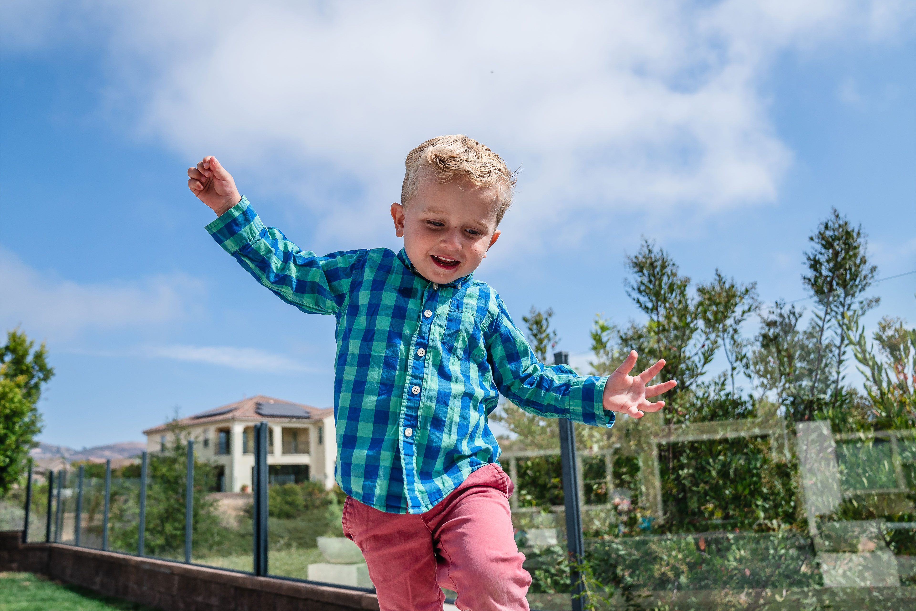 botm-oct2024-04_3840x2560web A young boy runs outside with both arms outstretched.