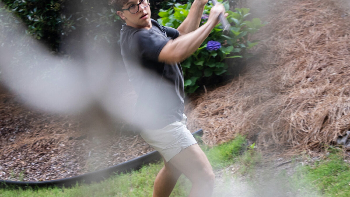 A photo of a teenager practicing. lacrosse outside.