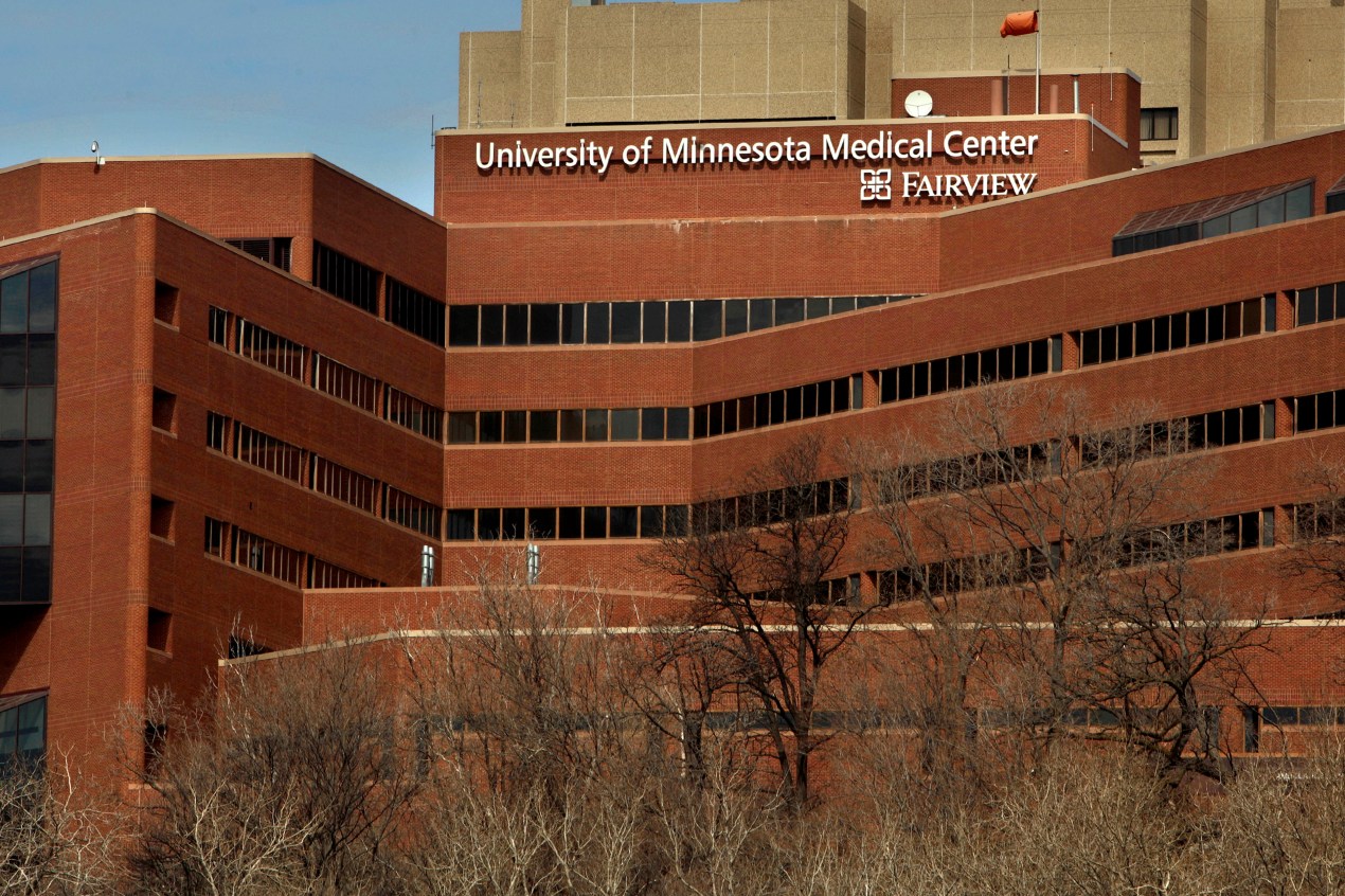 charity-care-05 A large brick building with large white letters at its top reading "University of Minnesota Medical Center Fairview"