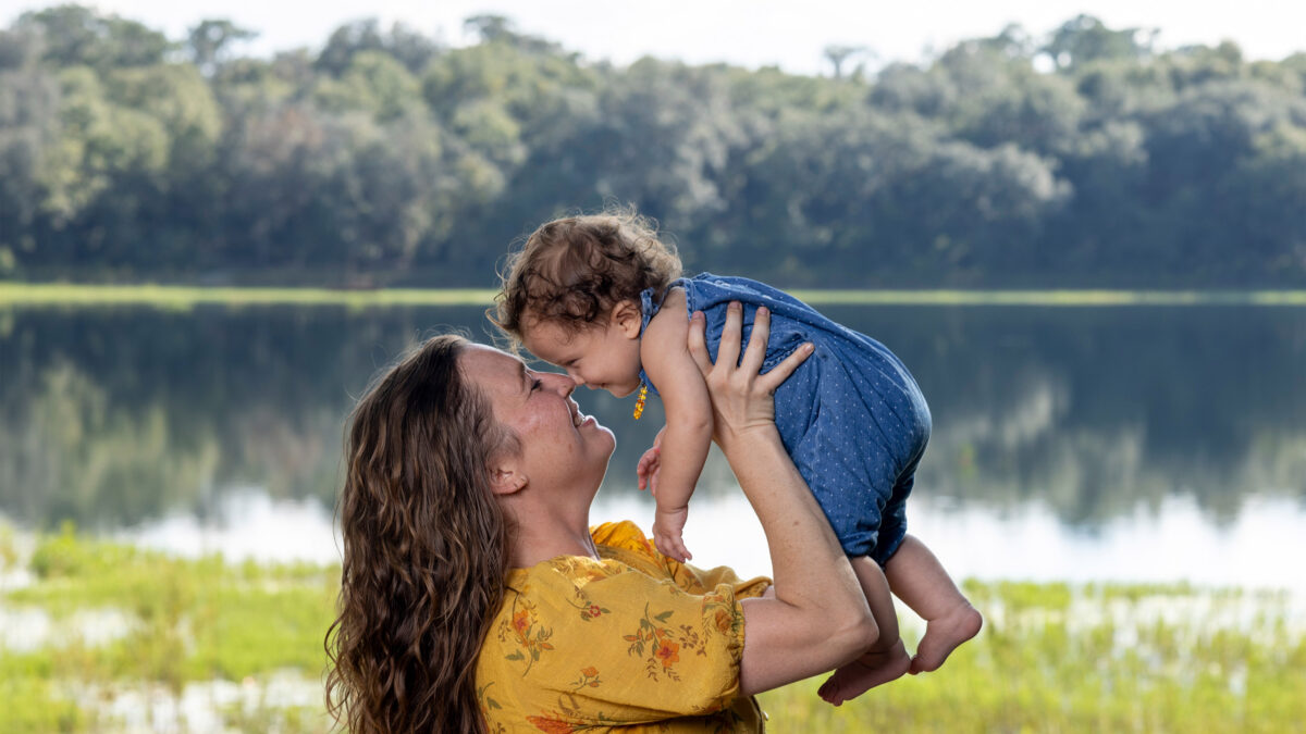 A photo of a mother holding her daughter up to her face.