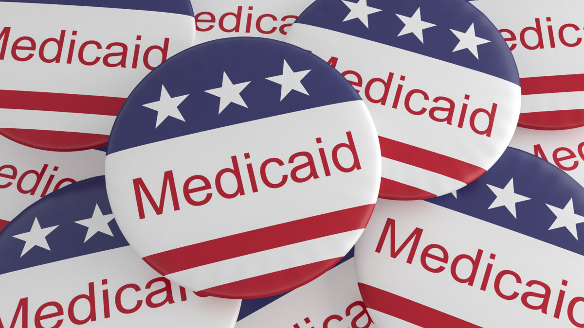 A pile of pins that say "Medicaid" and are decorated with an American flag pattern.