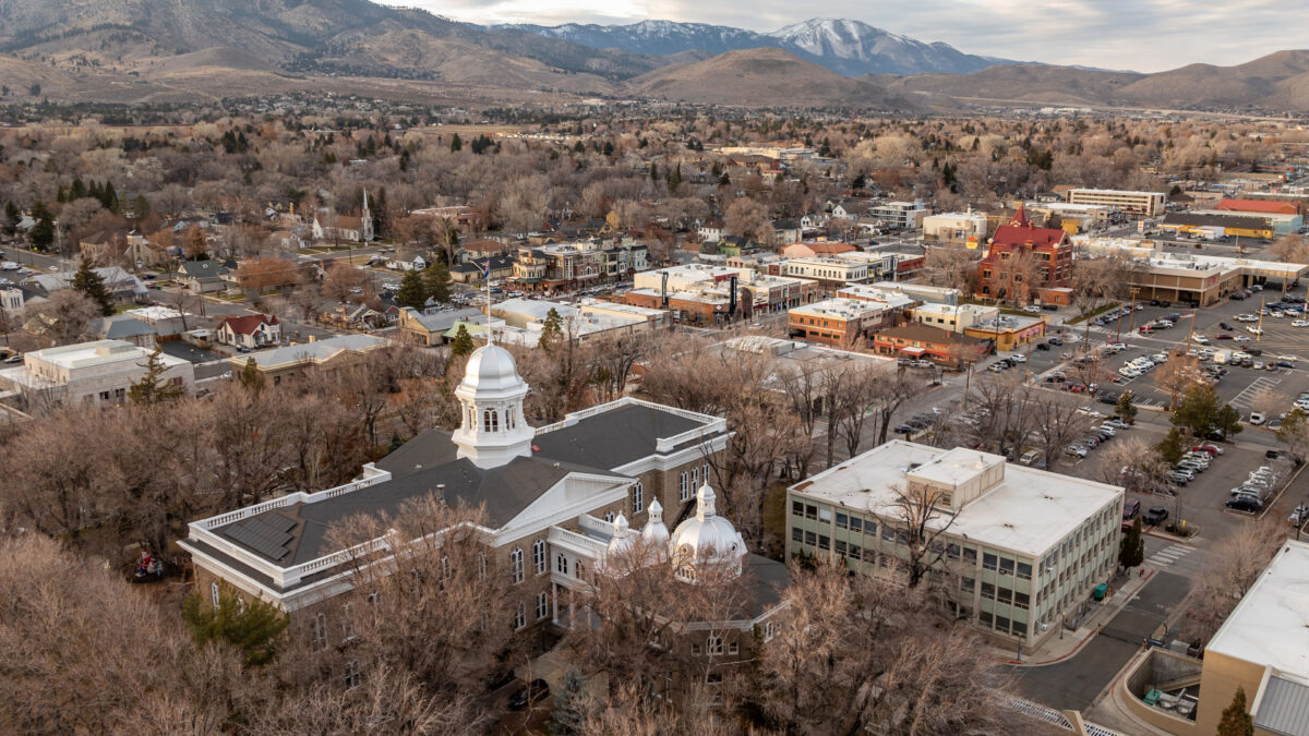 Aerial view of buildings in a city with foothills and mountains in the background