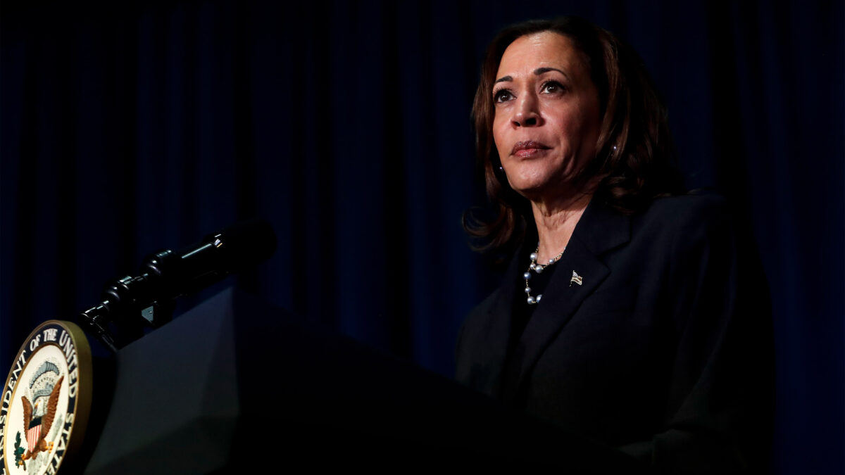 A photo of Kamala Harris on a stage in front of a podium with a microphone.