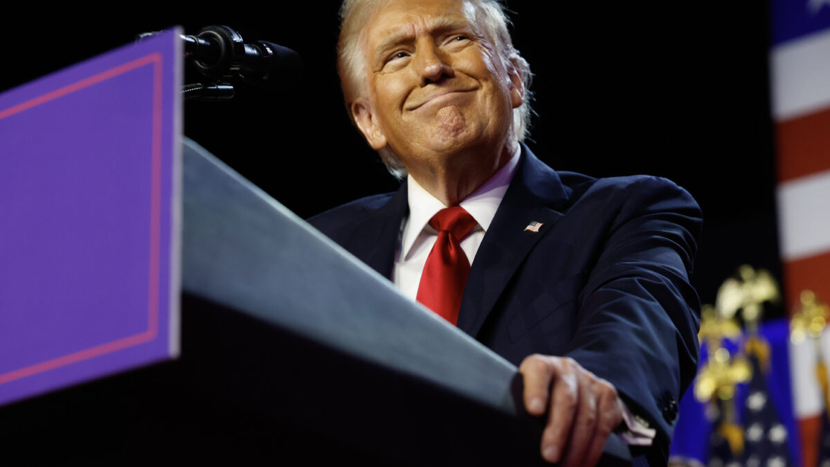 President Donald Trump holds a lectern before delivering his victory speech