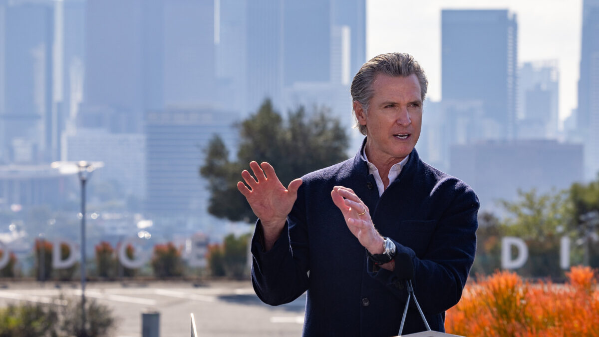 A photo of Gavin Newsom speaking at a press conference outside.