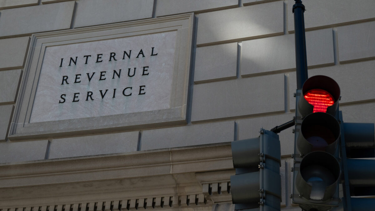 Photo of the exterior of a stone building with a sign that says "Internal Revenue Service" along with a traffic light next to it