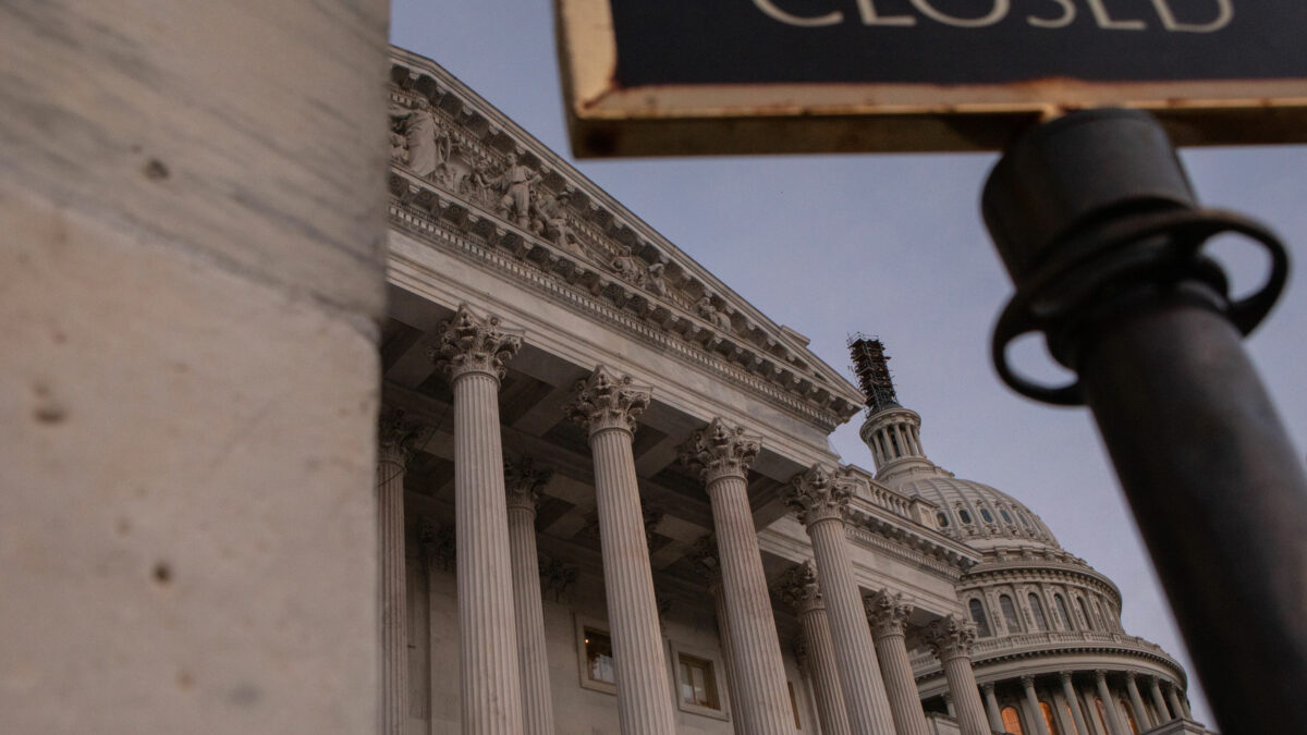 A photo of the U.S. Capitol. In the foreground is part of a sign that reads, "closed."