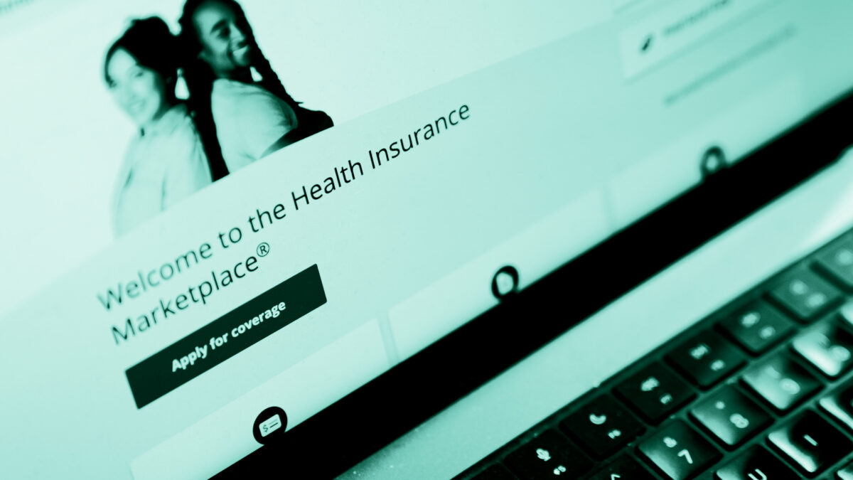 The healthcare.gov website seen on a laptop. The webpage reads, "Welcome to the Health Insurance Marketplace. Apply for coverage."