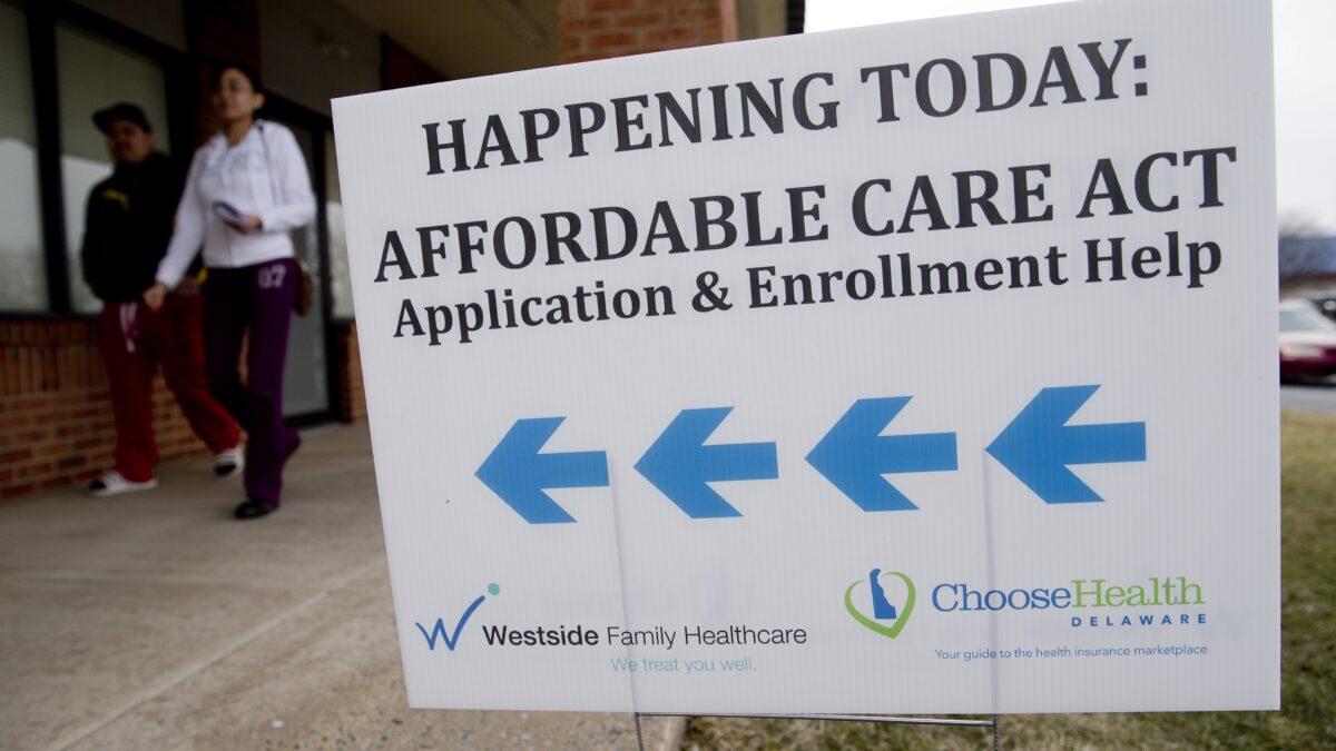 An Affordable Care Act application and enrollment help sign outside of a building.