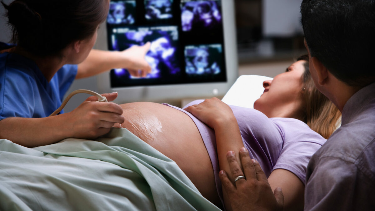 A pregnant woman receives an ultrasound.