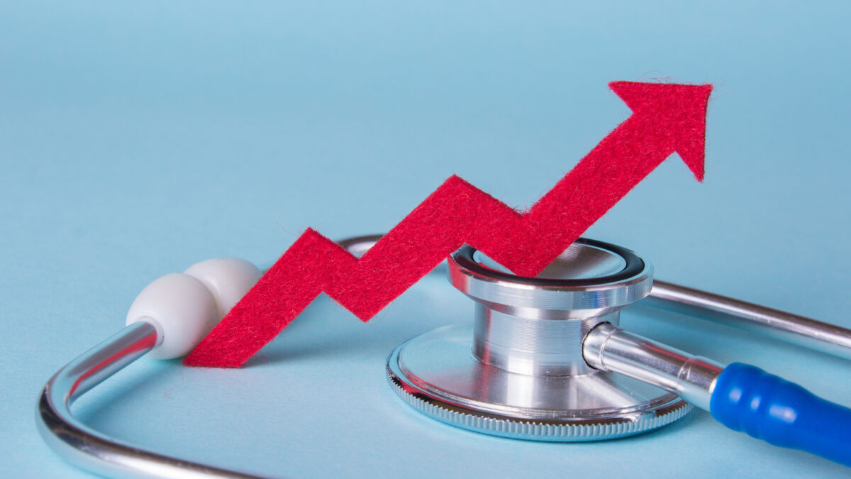 An upward red arrow rests on a stethoscope on a pale blue background.