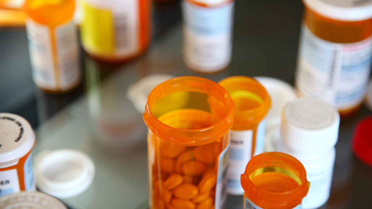 A photo of opened orange pill bottles arranged on a table.