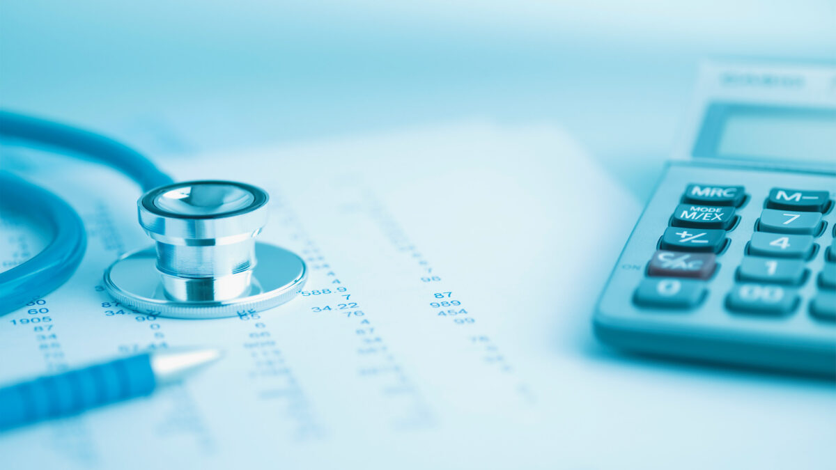 An image of a desk topped with a stethoscope, a medical paper, and a calculator.