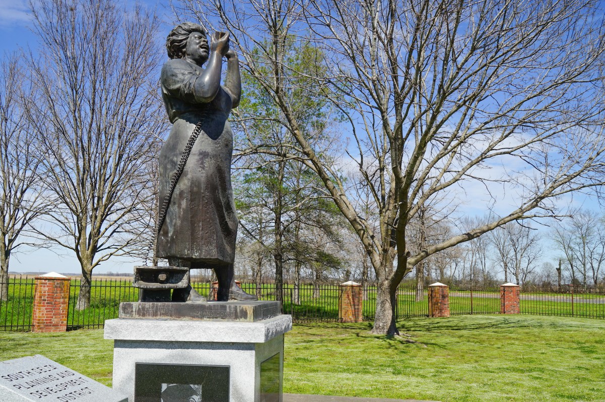 A statue of Fannie Lou Hamer in a park on a sunny day.