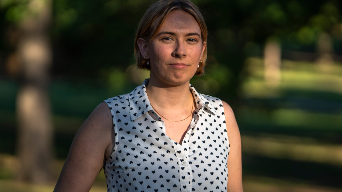 A portrait of a woman standing outside.