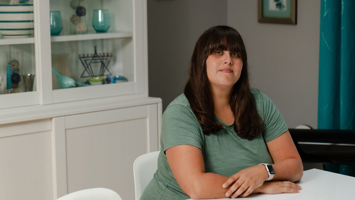 A portrait of a woman sitting at a dining room table.