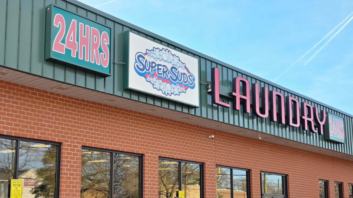 A photo of signage outside a laundromat: "24 hours, SuperSuds,laundry."