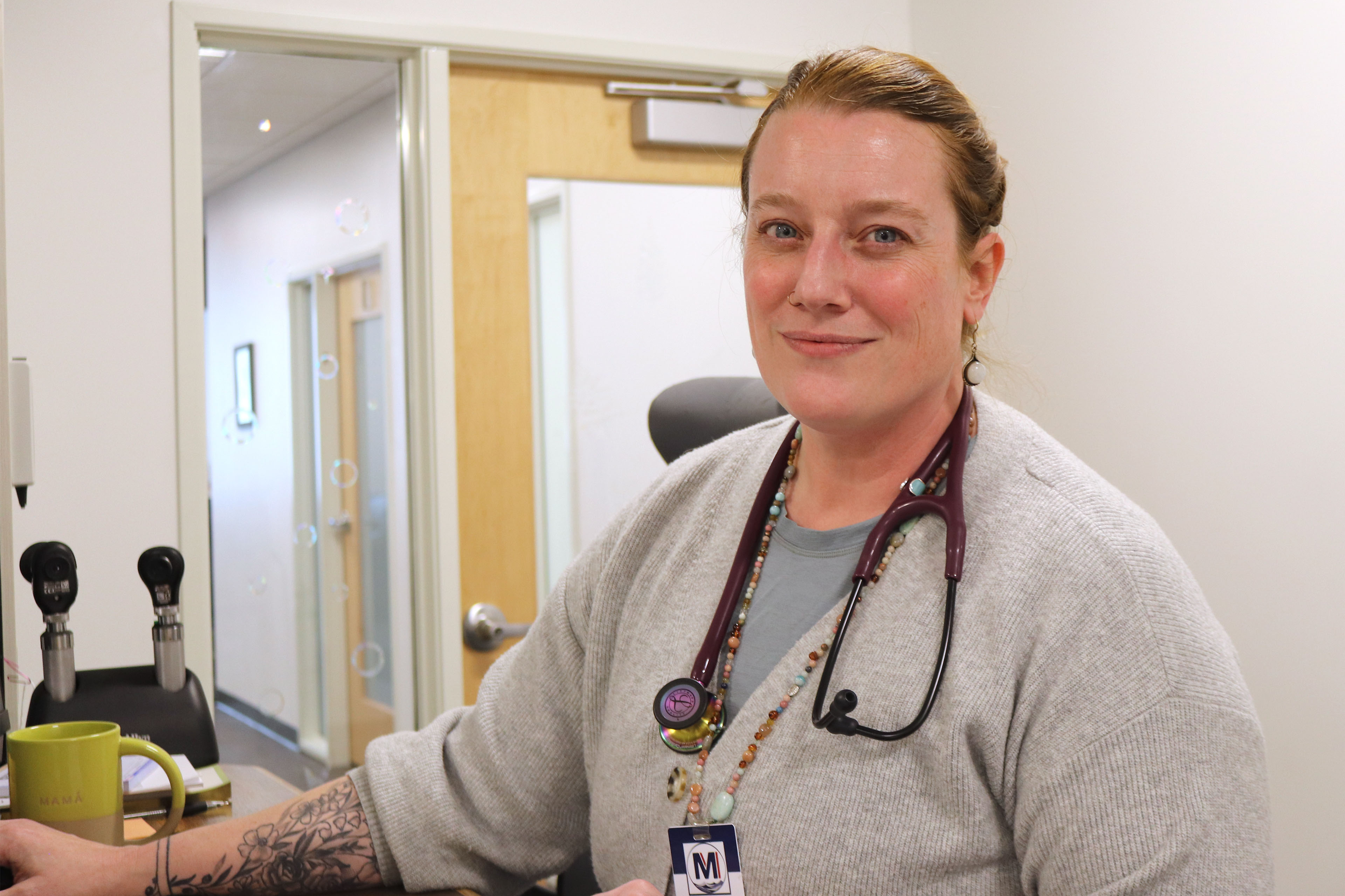A portrait of a female physician in a medical setting.