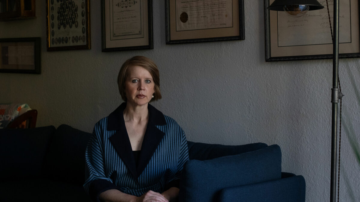 A photo of a woman sitting in her home.