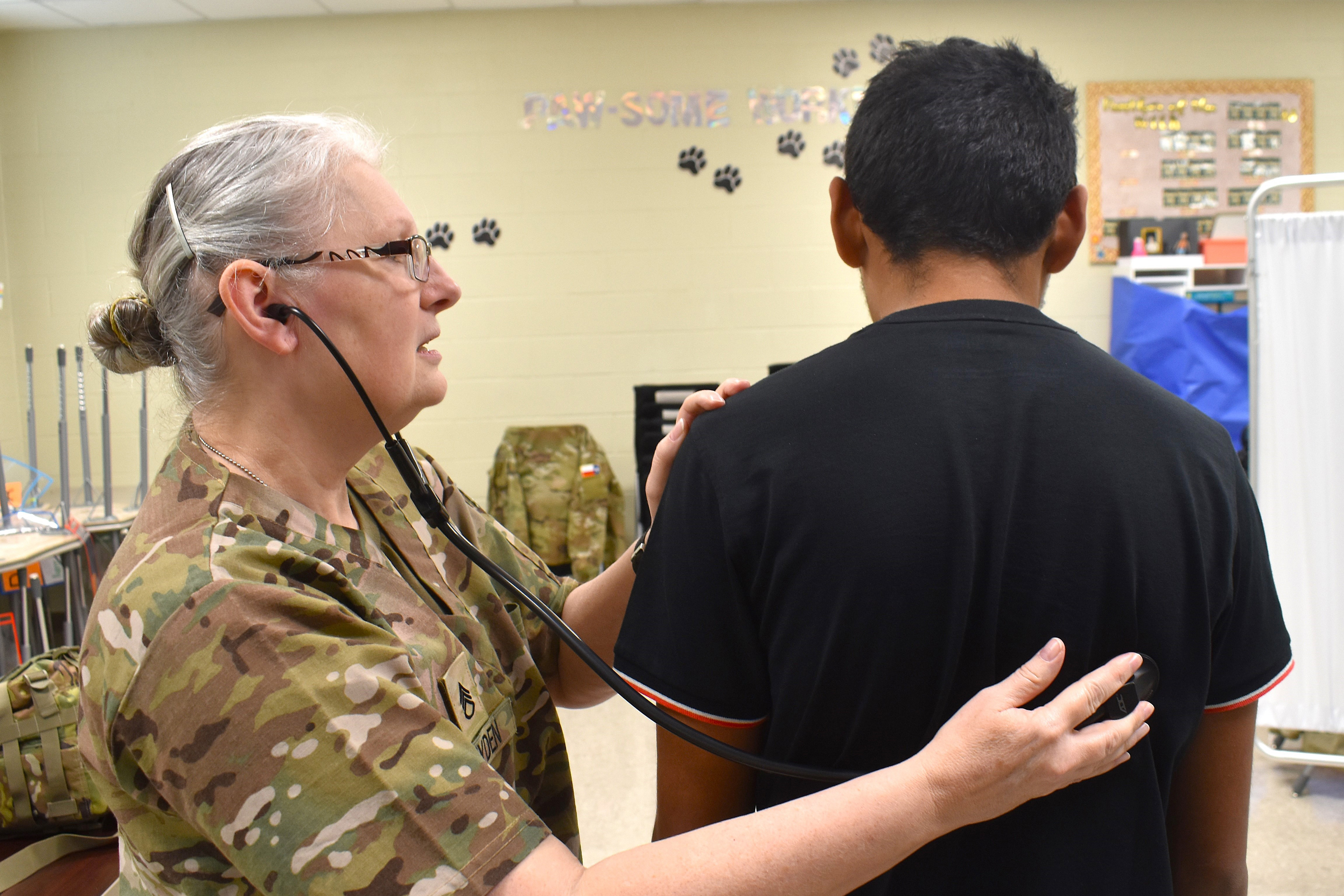 operationborderhealth-embed A photo of a Texas State Guard member checking a patient with a stethoscope.