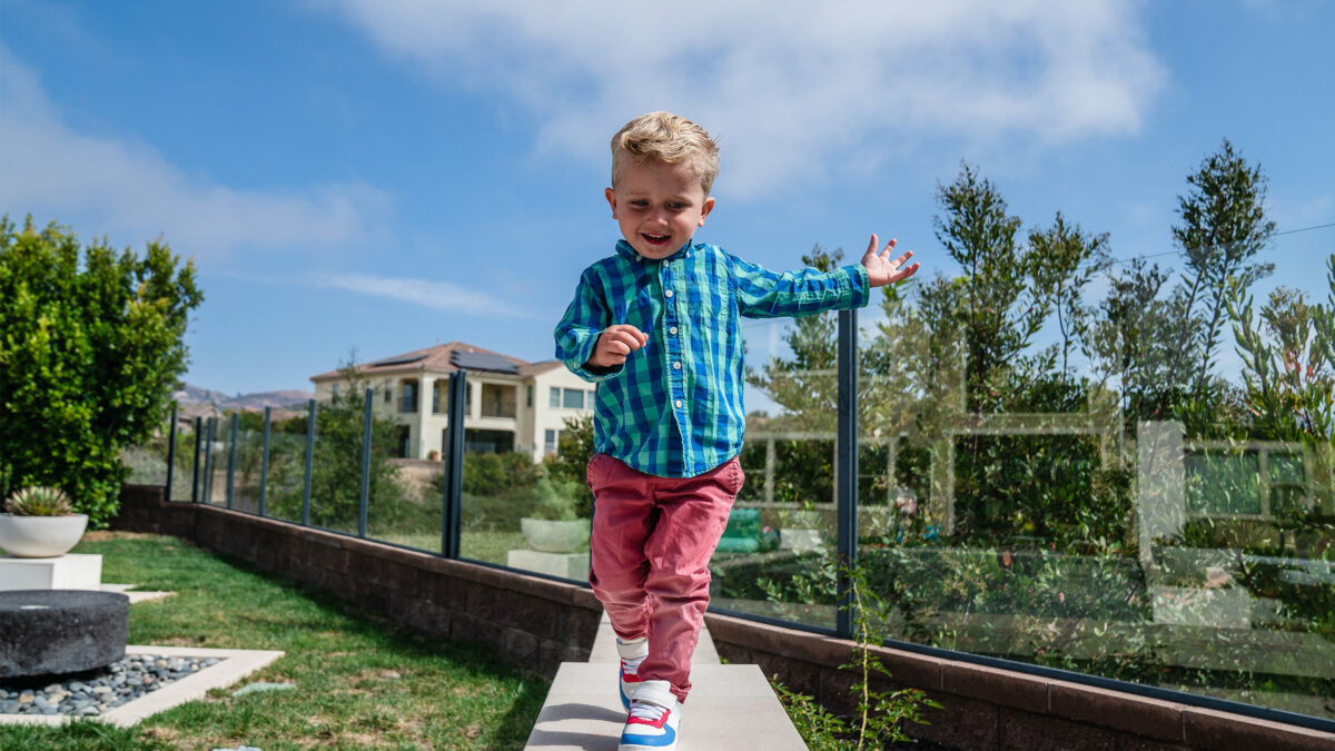 A photo of a toddler running in his backyard.