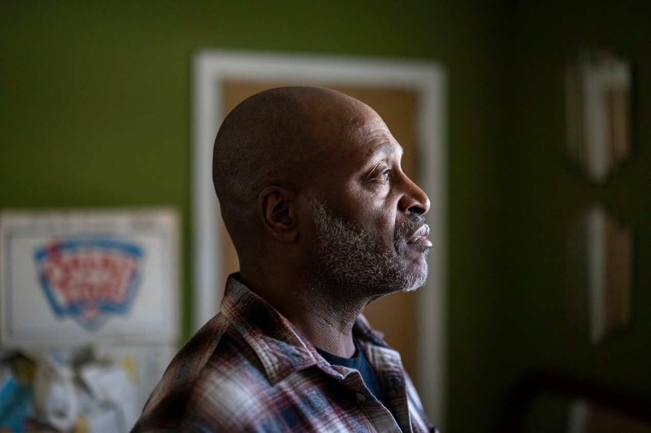 reit-leslie-adams-05-3840 A photograph of the profile of a man, facing sunlight through a window, as he stands in a room with green painted walls