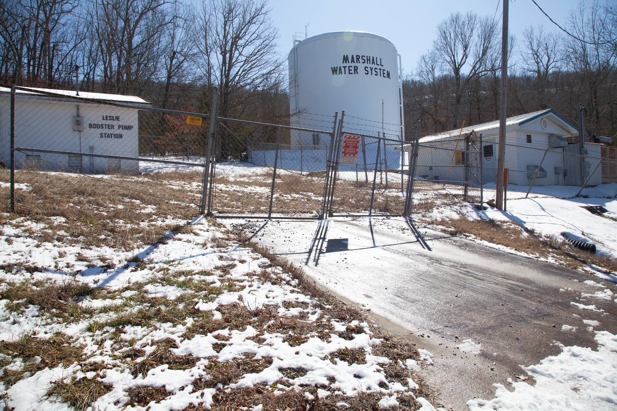 rural_dentist_11 A photo of water tank labeled "Marshall Water System" seen behind a fence.