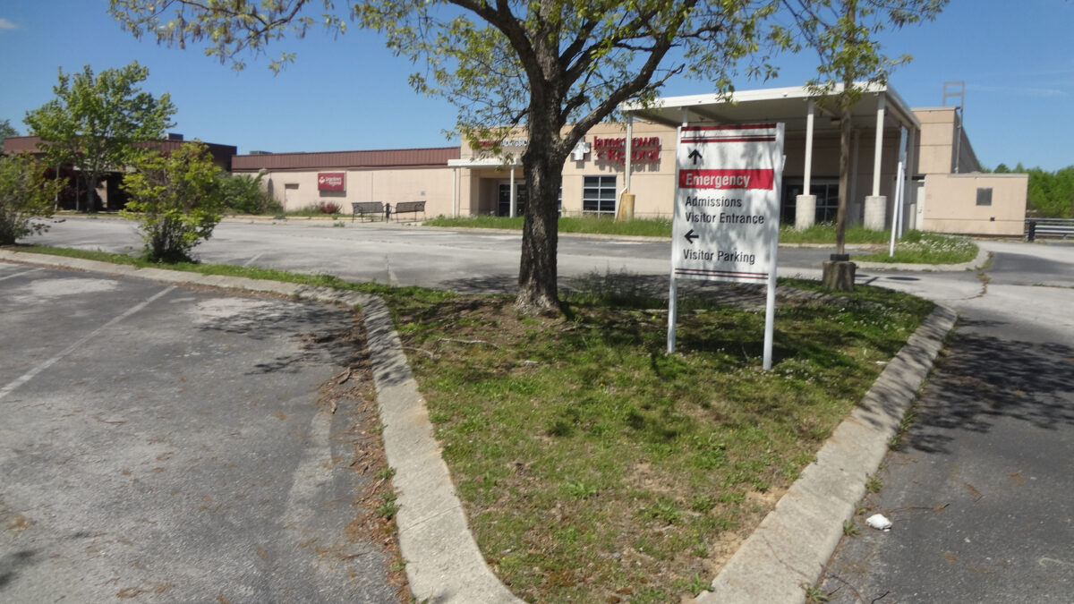 A photograph of a closed hospital taken from the parking lot.