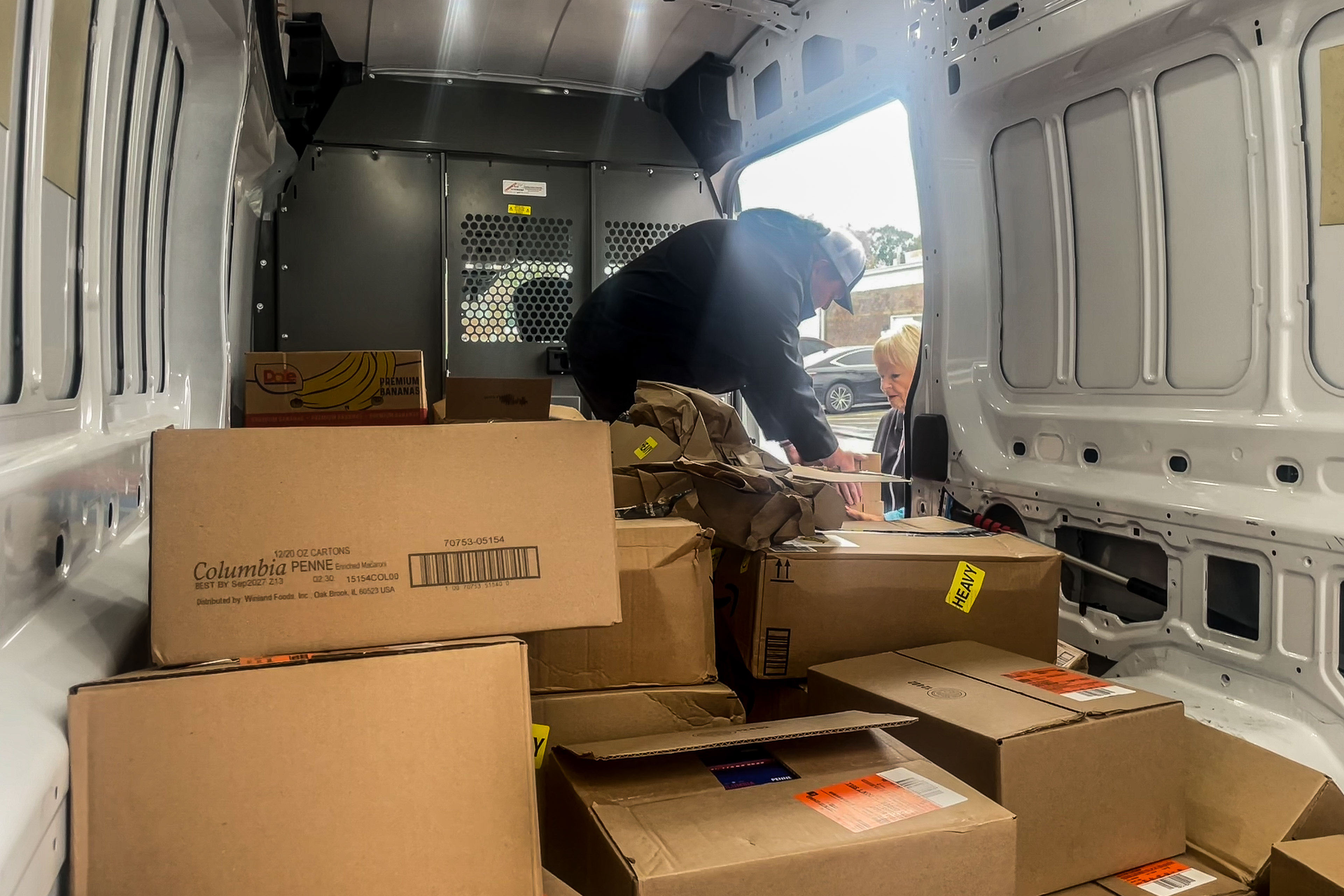snap_05 A man unpacks boxes from the back of a white van