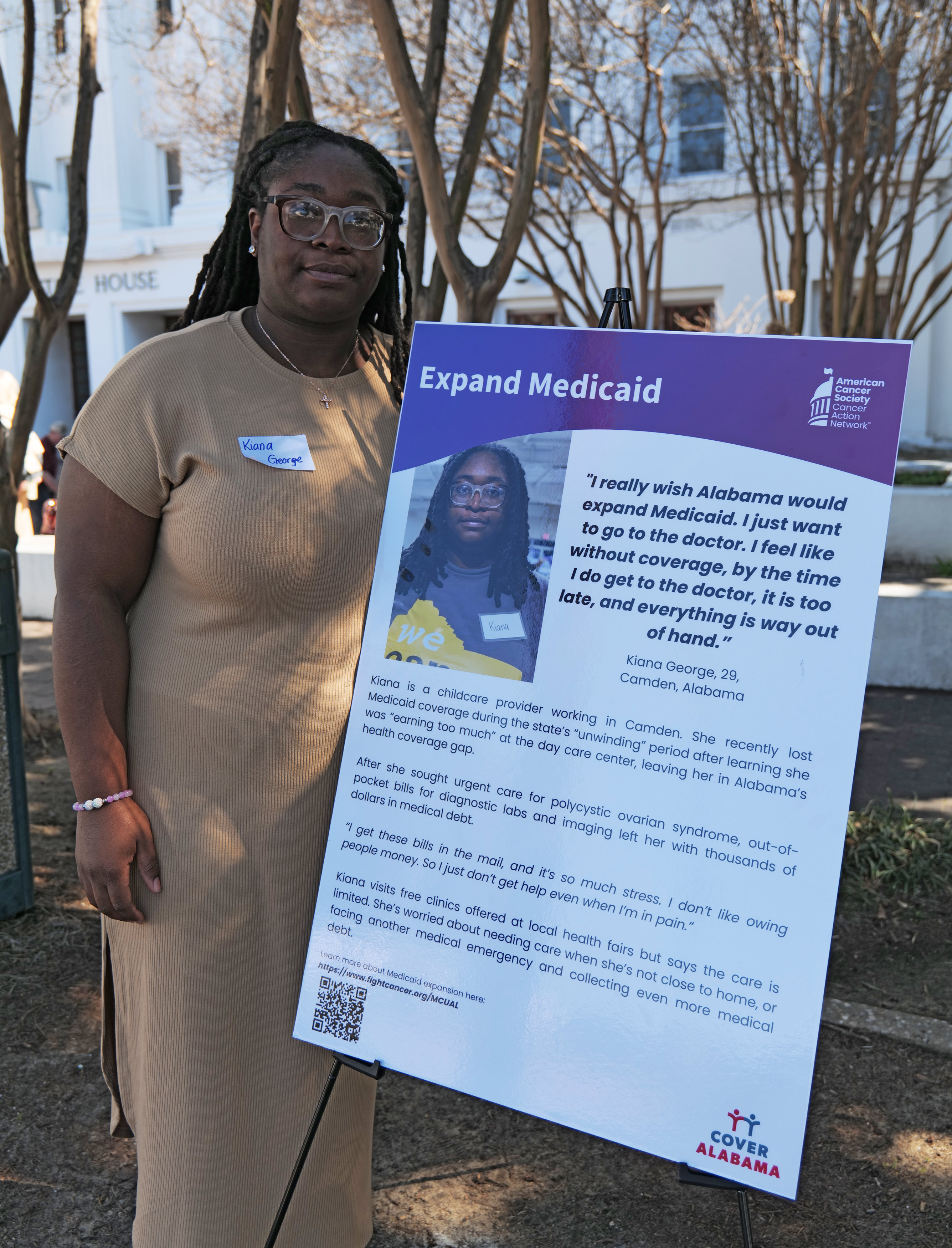 uninsured-07-resized A photo of Kiana George standing for a photo outdoors. She stands next to a sign that reads, "Expand Medicaid," followed by a quote describing her opinions on the issue and an explanation of her story.