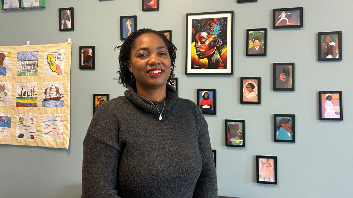 A photo of California state Senator Akilah Weber Pierson indoors. Behind her is a wall covered in colorful art prints.